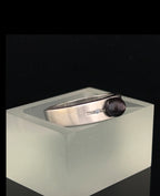 Breite ringschine mittig offener dünner rechteckiger spalt große schwarze perle rechts und links davon je 1 Diamant