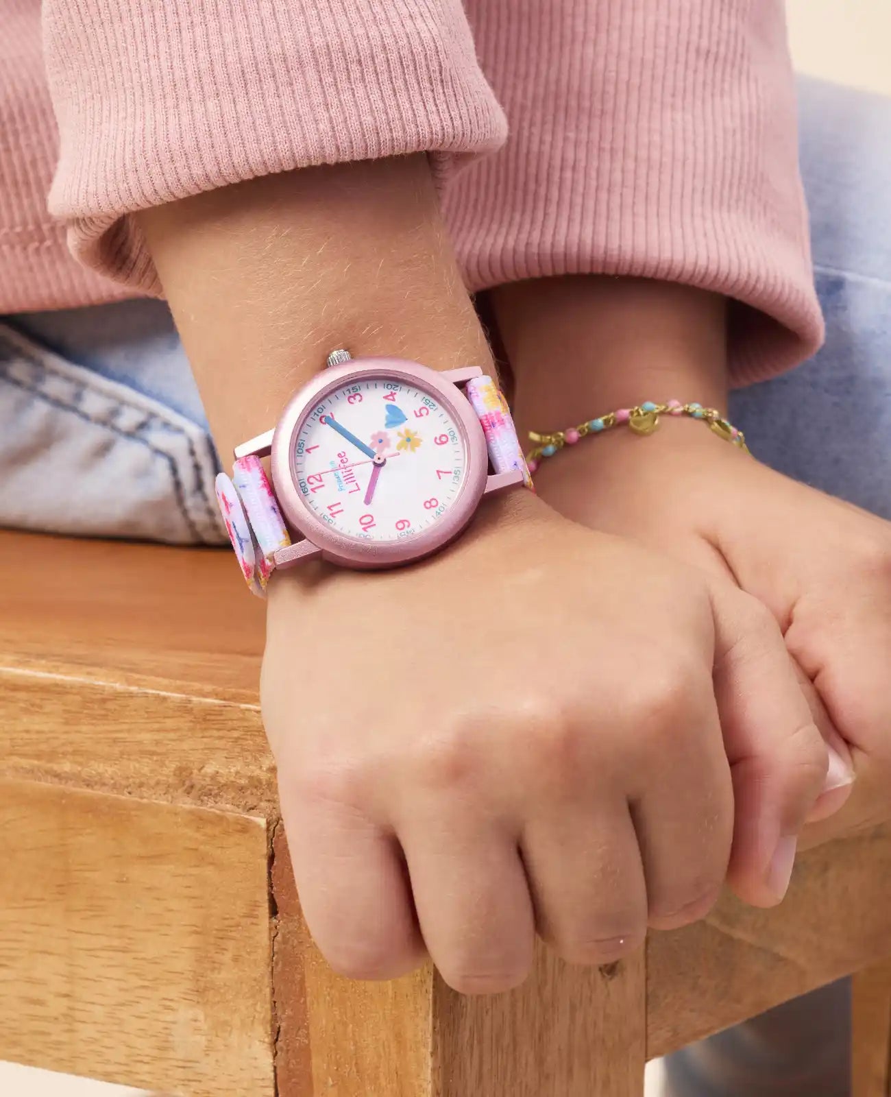 Rosa Kinderuhr mit arabischen zahlen und Blumenmotiven am textilarmband