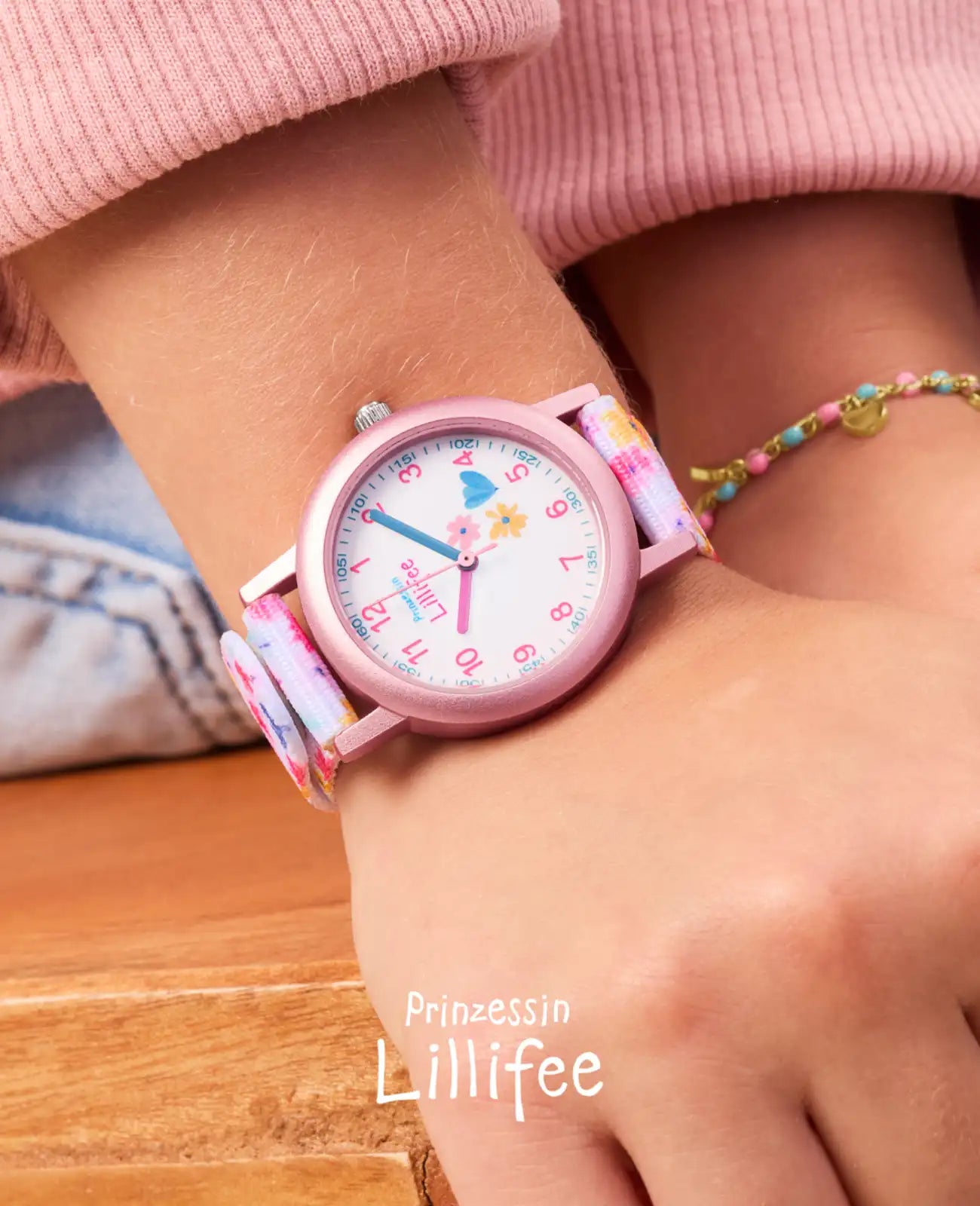 Rosa Kinderuhr mit arabischen zahlen und Blumenmotiven am textilarmband